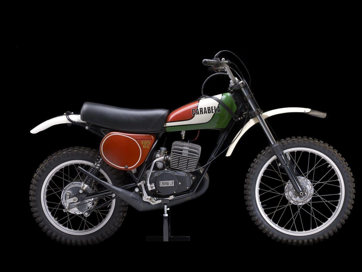A green and red dirt bike on a black background.