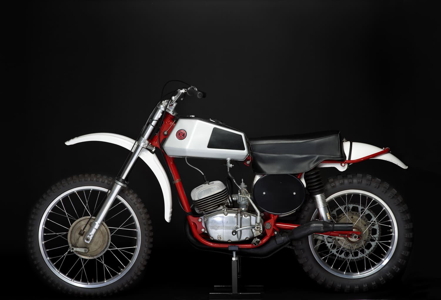 A white and red dirt bike on a black background.