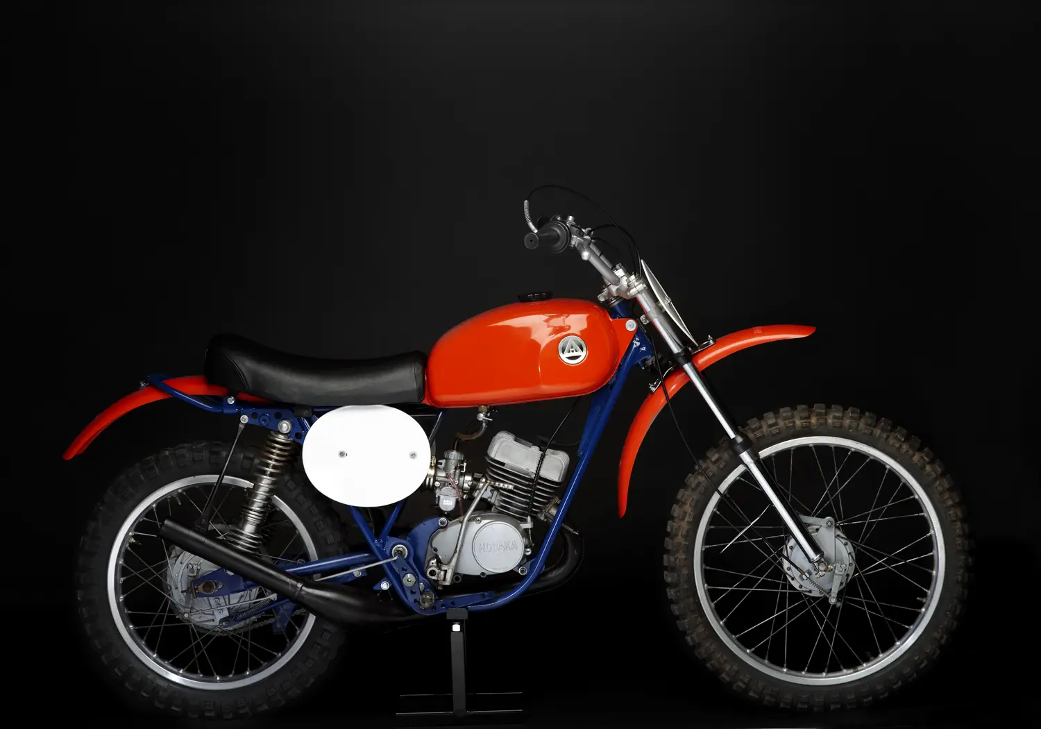 A red and blue dirt bike on a black background.