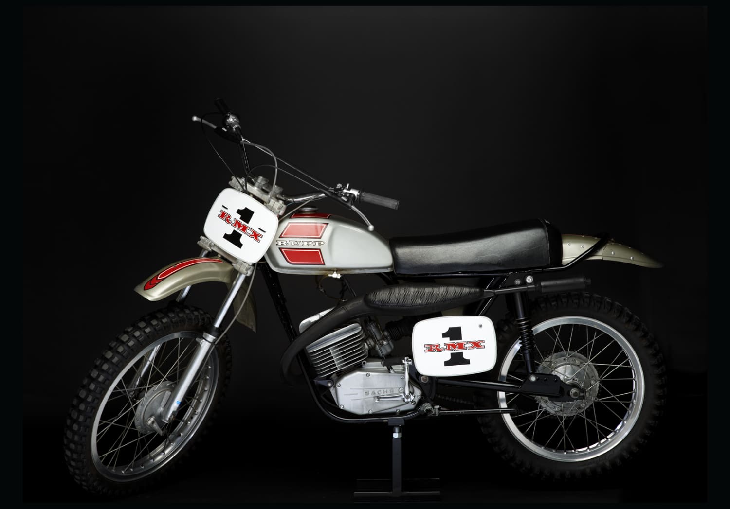 A dirt bike is on display against a black background.
