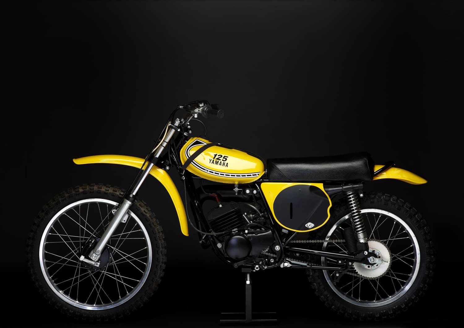 A yellow dirt bike on a black background.
